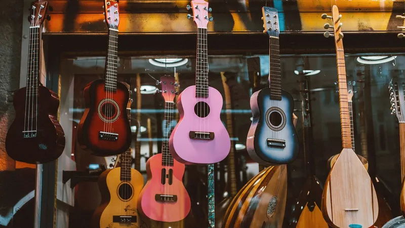 Ukuleles, mandolins, and small guitars hanging on a wall