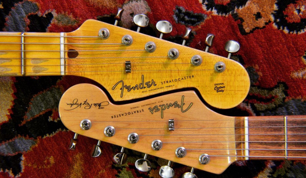 Two electric guitar headstocks on a patterned rug